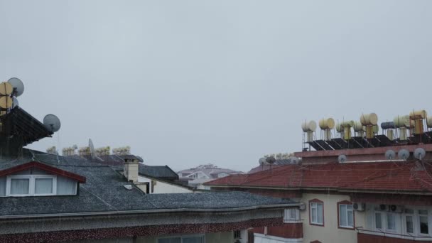 Granizo blanco con nieve cayendo en los techos de la casa durante la tormenta de granizo. Cielo dramático y nubes — Vídeo de stock