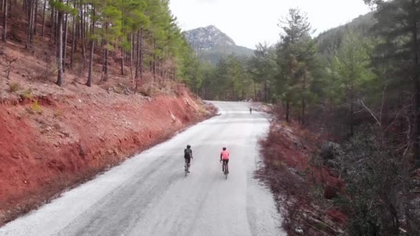 Bisikletçiler dağlarda bisiklet sürerler. Orman dağlarında yokuş yukarı tırmanan profesyonel bisikletçiler. — Stok video