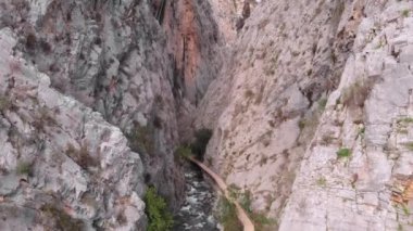 Nehir kanyonunda uçuyor. Engebeli dağ kanyonunda güzel kayalık manzarayla uçmak