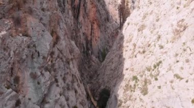 Kayalık dağlarla çevrili nehir kanyonunda uçan insansız hava aracı. Derin, dar kayalık kanyon