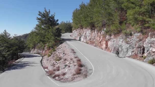 Andar de bicicleta nas montanhas. Mulher de vestuário preto andando de bicicleta de estrada através da montanha — Vídeo de Stock