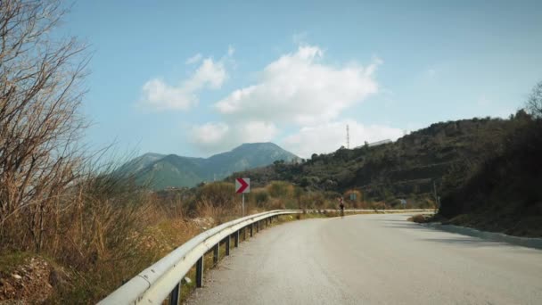 Ciclista ciclista descendo colina de montanha. Mulher atleta andar de bicicleta de estrada — Vídeo de Stock