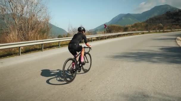 Kadın bisikleti. Bisikletçi kask ve bisiklet kıyafetleriyle bisiklet sürüyor. Dağlarda bisiklet sürmek — Stok video