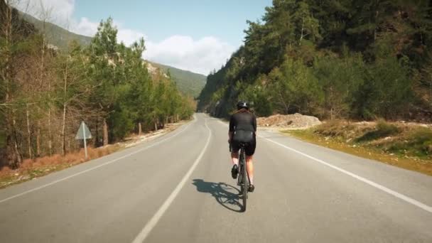 Ciclista professionista che pedala in bicicletta attraverso il passo di montagna. Gite in bicicletta sulla maratona di montagna in bicicletta — Video Stock