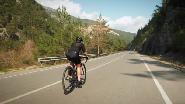 Radfahren und Triathlon. Professionelles Rennradtraining auf dem Fahrrad. Frau fährt mit Fahrrad in den Bergen — Stockvideo