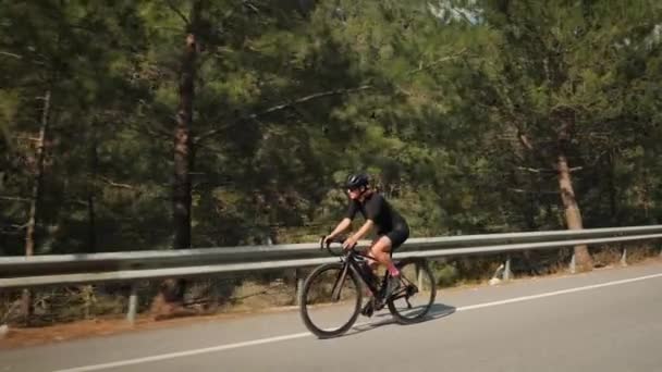 Triatleta profissional do sexo feminino pedalando na estrada enquanto se prepara para a corrida de triatlo — Vídeo de Stock