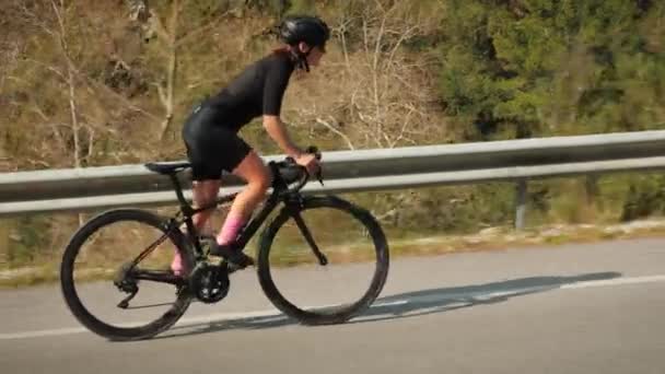 山の丘を通って道路の自転車に登るスポーツ女性にフィットします。自転車の専門的なサイクリストトレーニング — ストック動画