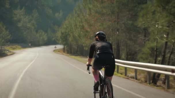 Entrenamiento profesional de ciclistas en bicicleta de carretera al atardecer. Atleta femenina montando en bicicleta en las montañas — Vídeos de Stock