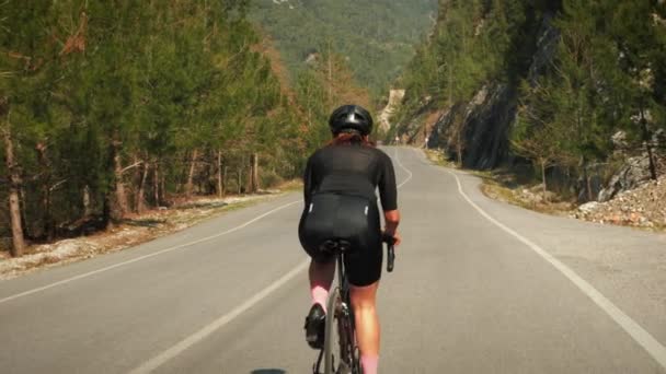 Radfahrer auf Fahrrad in den Bergen. Triathlet auf Rennrad durch die Berge bei Sonnenuntergang — Stockvideo
