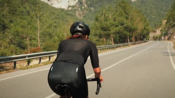 Ciclista atletico che calpesta i pedali della bicicletta su strada durante un intenso allenamento in mountain bike — Video Stock