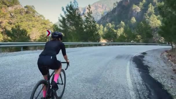 女性のサイクリング プロのロードサイクリストは日没時に自転車に乗る トライアスロンとサイクリングのコンセプト スポーツの動機 アクティブな健康的なライフスタイル 自転車で女性アスリートのトレーニング ハードワークアウトを行う — ストック動画