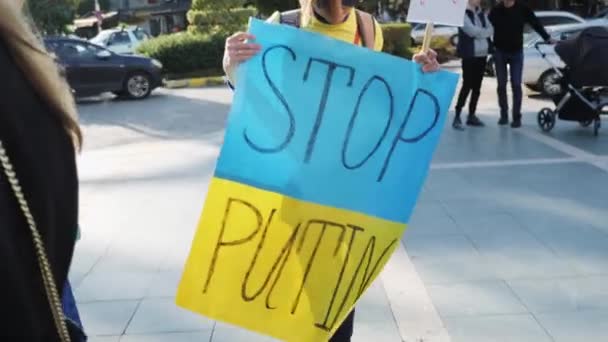 Жінка стоїть з прапором Стоп Путін. Мирний мітинг проти вторгнення Росії в Україну: Аланья, Туреччина - 26.02.2022 — стокове відео