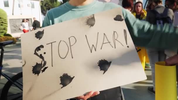 Female standing with banner Stop War at protest against Russia invasion in Ukraine. Rally to support Ukrainian people. Alanya, Turkey - 26.02.2022 — Stock Video