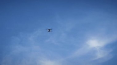 İHA gökyüzünde uçuyor. Mavi gökyüzünde uçan ve uçan bir kuadkopter.