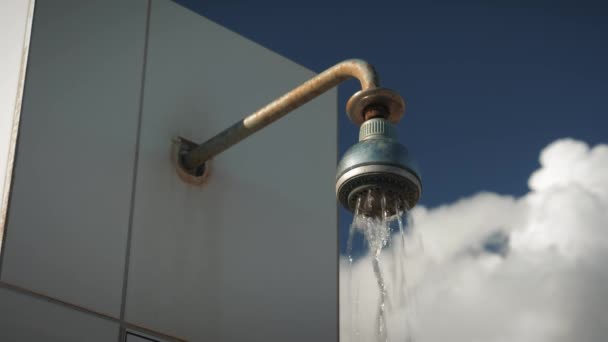 Open air outdoor beach shower. Water falls from outdoor shower against blue sky — Stock Video