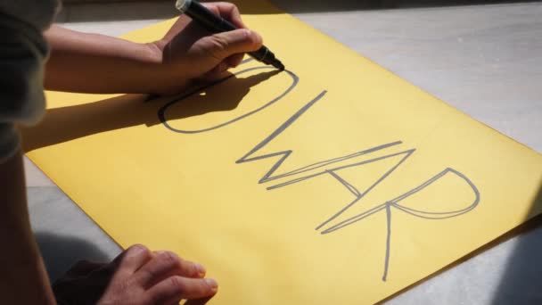Escribiendo en papel amarillo No War para apoyar a Ucrania contra la invasión rusa — Vídeo de stock