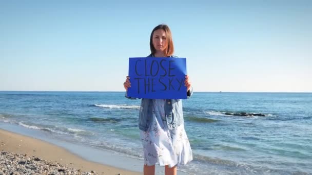 Triste joven protestando contra la guerra en Ucrania con pancarta Cerrar El Cielo — Vídeos de Stock