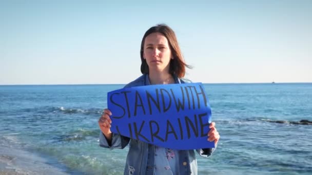 Νεαρό λυπημένο Ουκρανό κορίτσι υψώνει μπλε σημαία με εγχάρακτη στάση με την Ουκρανία — Αρχείο Βίντεο