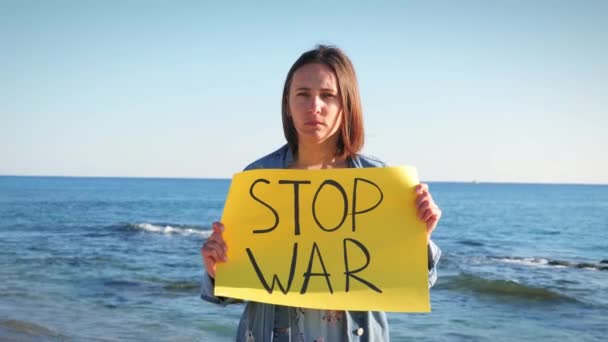 Oproep tot vrede tussen Rusland en Oekraïne. Vrouwelijke stand met teken Stop Oorlog — Stockvideo
