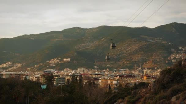 Seilbahn fährt gegen Stadtbild. Seilbahn bei Sonnenuntergang — Stockvideo