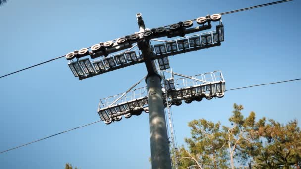 Stěhováky na lanovce. Funicular pohybující se přes stromy proti modré obloze — Stock video