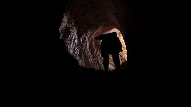 Путешественник спускается с веревкой в пещеру. Человек, исследующий пещерный туннель — стоковое видео