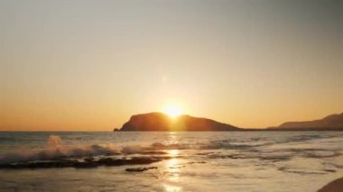 Denizde turuncu tropik gün batımı. Yazın kayalık yamaçtan güneş batıyor.