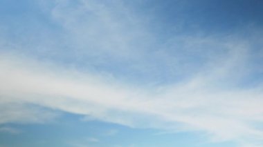 Pofuduk bulutlar açık mavi gökyüzüne karşı. Gökyüzünde hızlı hareket eden bulutlar, zaman aşımı