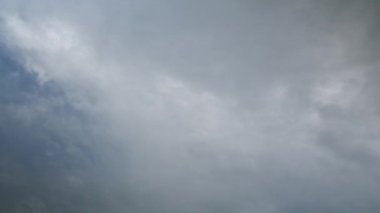 Gri gökyüzünde hızlı hareket eden dramatik yağmurlu bulutlar. Fırtına bulutları ve gri gökyüzü