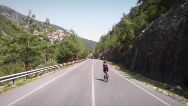 Donna che sale in montagna in bicicletta su strada. Esercizio ciclistico di resistenza — Video Stock