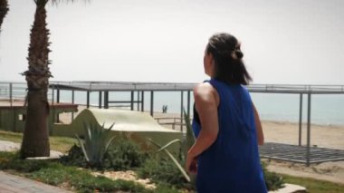 Limanda koşan bir kadın. Kadın sahil ve sahil boyunca koşuyor. Spor konsepti