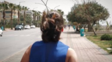 Çalışan kavram. Güneşli yaz gününde gezinti güvertesinde koşan bir kadın. Spor konsepti