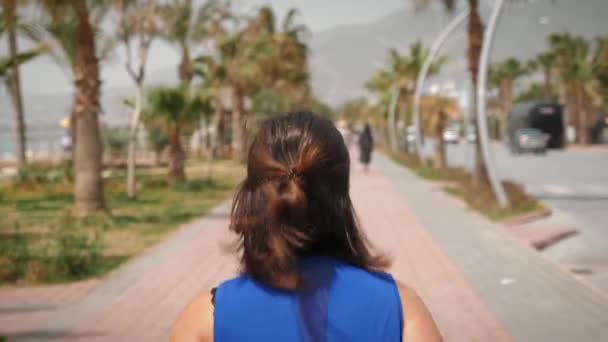 Energická žena běží na promenádě podél pobřeží za slunečného dne — Stock video