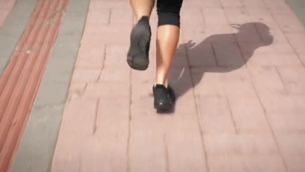 Sportive female legs running on promenade in morning. Woman feet jogging outdoor — Stock Video