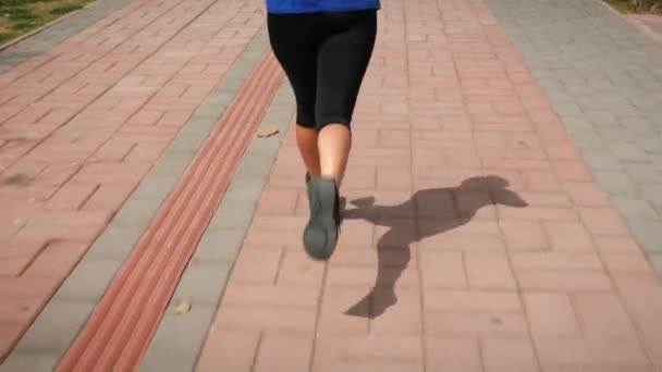 Springa utomhus. Kvinnliga ben joggar längs strandpromenaden. Aktiv idrott — Stockvideo