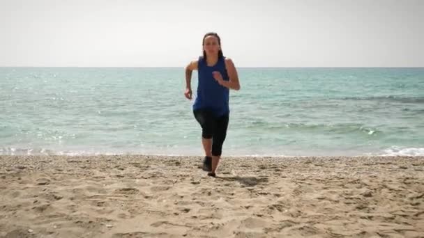 Donna che corre sulla spiaggia con il mare sullo sfondo. atletica femminile jogging all'aperto — Video Stock