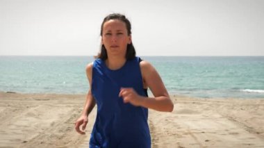 Çalışan kavram. Sabah kumsalda egzersiz yapan bir kadın. Deniz kenarında koşan bir kadın.