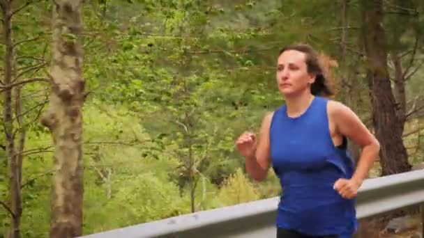 Femme courant vite sur la route de montagne, se préparant pour la course à pied ou le marathon — Video