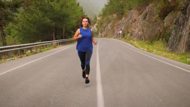 Fit woman maintaining active healthy lifestyle, running in mountains in morning — Stock Video