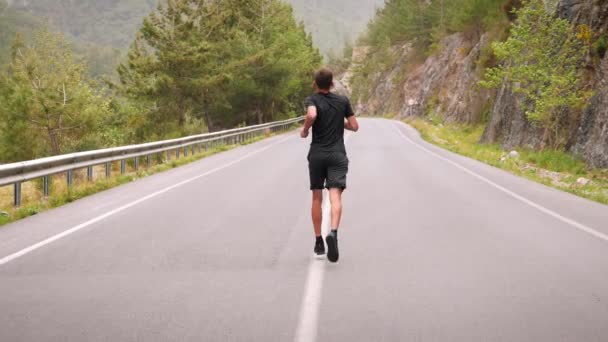 Corredor de maratón corriendo en las montañas. Triatleta corriendo al aire libre. Deporte activo — Vídeo de stock