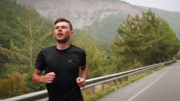 En man som springer på maraton i bergen. Manlig löpare träning och träning utanför — Stockvideo
