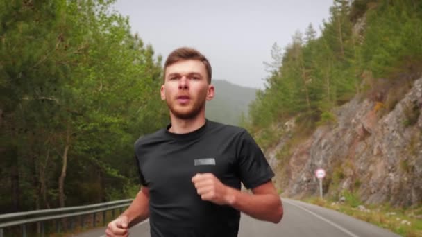 Homem de esportes correndo em estrada de montanha vazia, exercitando-se para maratona de corrida — Vídeo de Stock