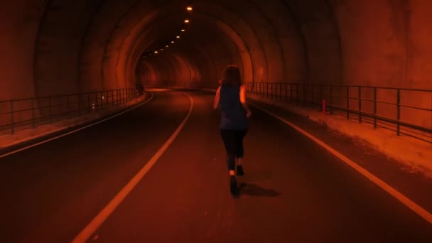 トンネルを走っている若い女性。トンネルを駆け抜ける女選手 — ストック動画