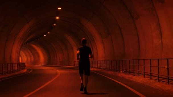 Running concept. Young muscular man runs along tunnel, exercising endurance run — ストック動画