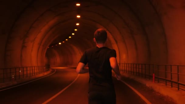 Man athlete running along tunnel in mountains. Male runner exercising outdoors — ストック動画