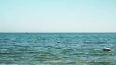 Kapatılan şamandıralar denizde dalgalar üzerinde yüzerler. Yaz gününde şeffaf su ve dalgalar