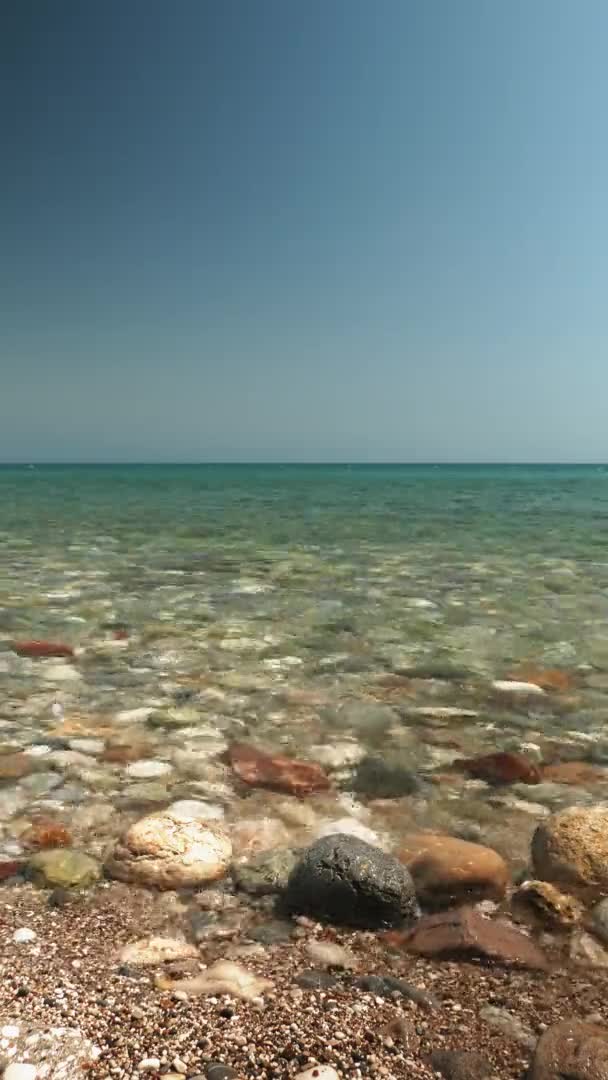 Pebble sea beach with clear tranquil sea water waves. Vertical video — Vídeo de Stock