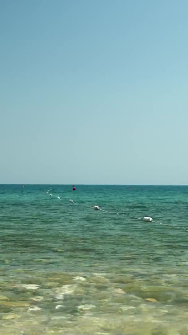 As bóias flutuam na superfície da água do mar. Vídeo vertical.Férias de verão — Vídeo de Stock