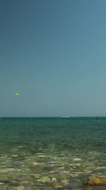 Deniz paraşütü. Tekneye bağlı sarı paraşüt havada süzülüyor.