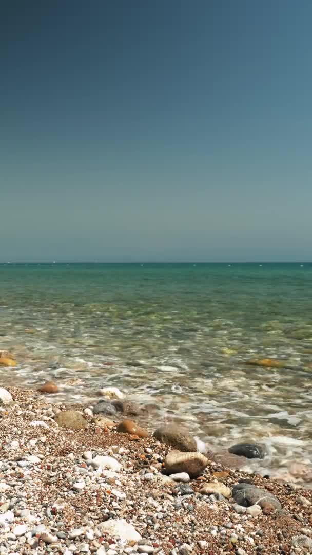 Amazing tranquil seascape with clear sea water and pebble beach. Vertical video — Vídeo de Stock